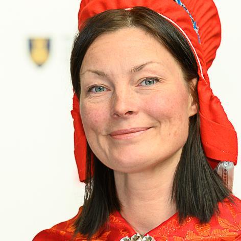 Dame med mørkt hår ikledd samisk kofte med hodeplagg - Klikk for stort bilde